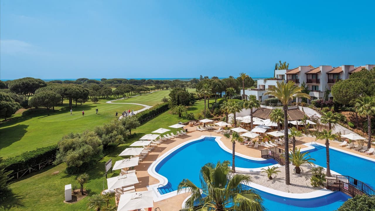 The pool and white, terracotta-roofed buildings at El Rompido Precise Golf Resort