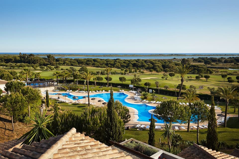 The pool and golf course at El Rompido, with the estuary and the Atlantic beyond