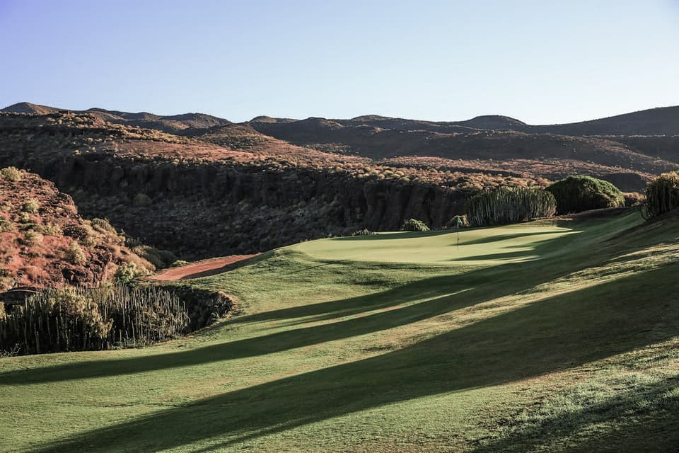 A fairway on Salobre's New Course between red volcanic ridges
